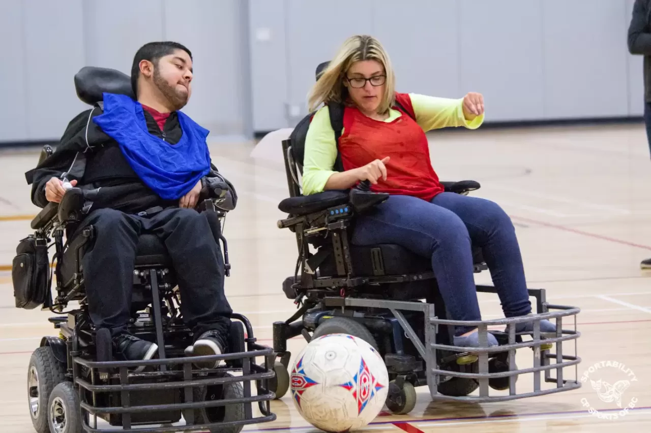 Powerchair soccer participants in a gym