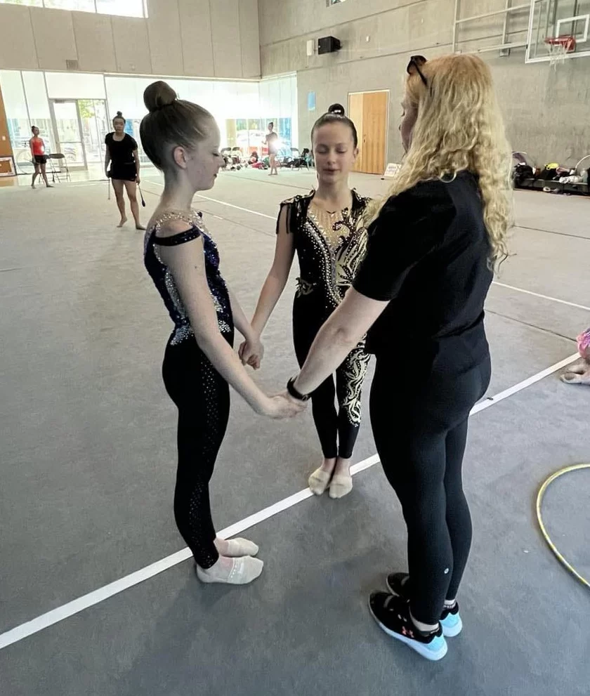 Athletes and coach at a rhythmic gymnastics session