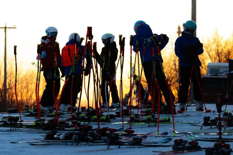 Ski NB athletes on the mountain at sunset.