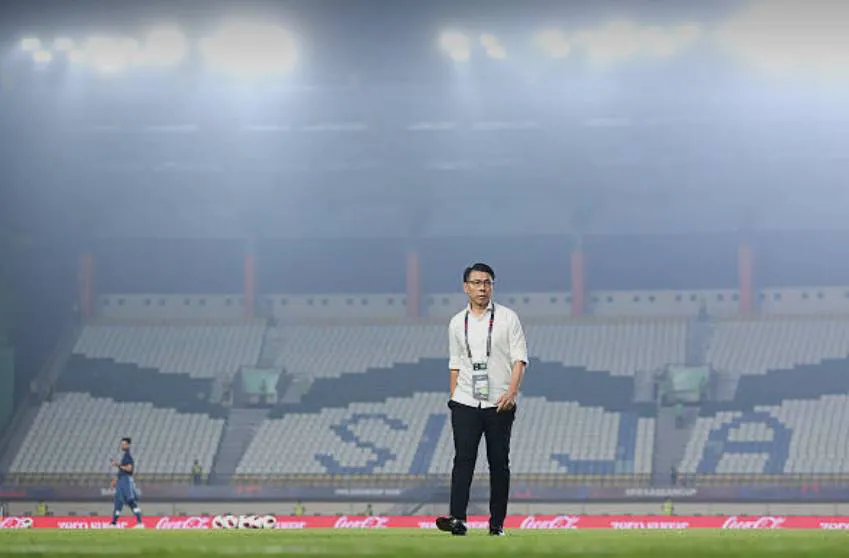 Tournament operations professional standing on a soccer field inside a stadium